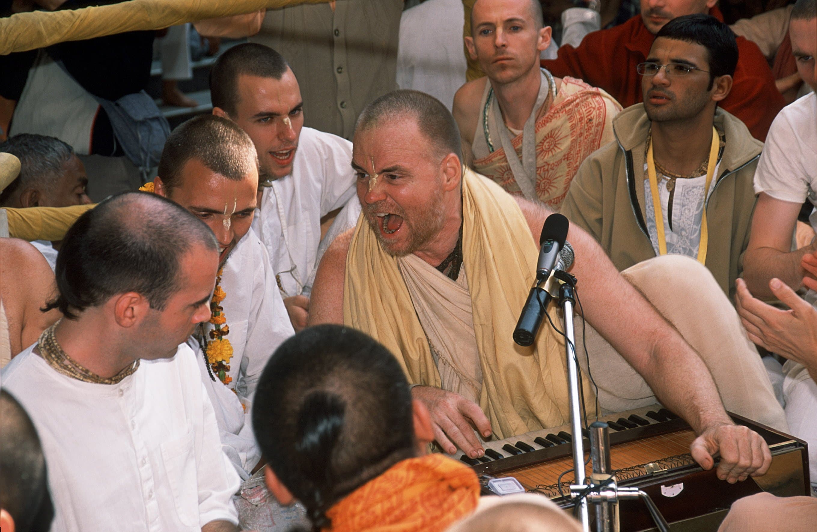 A kirtan leader singing with devotees